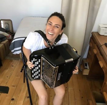 élève souriante en plein cours d'accordéon dans un appartement lyonnais